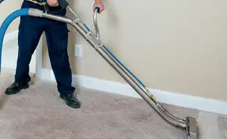 Professional operating a liquid removal machine on a carpeted floor in Birmingham, AL